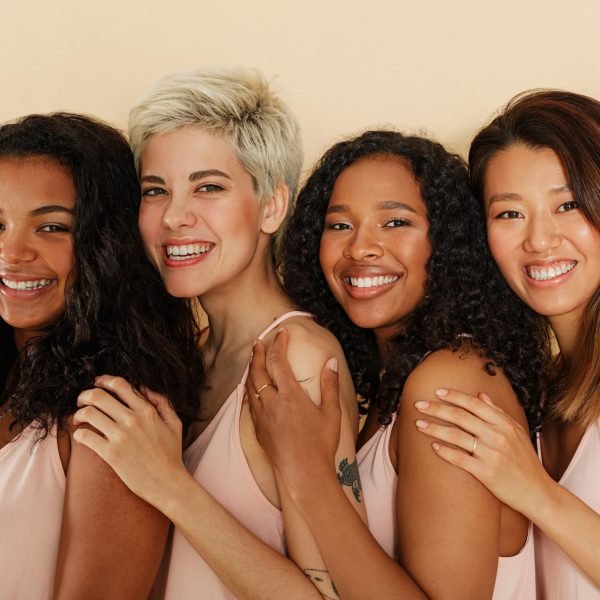 Four women of different body types and skin tones looking at camera